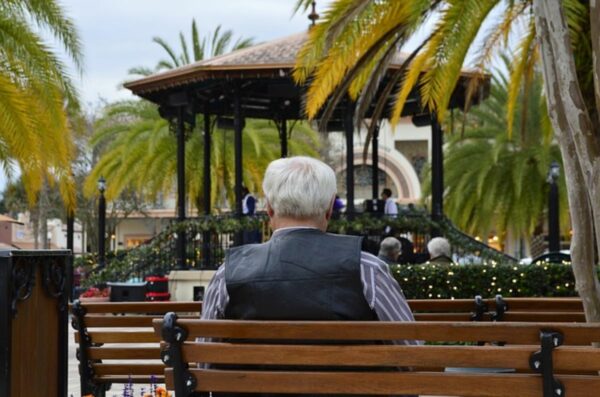 A man is sitting on a bench making adjustments for retiring in France.